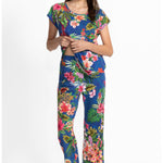 Woman wearing a colorful floral pajama set on a white background