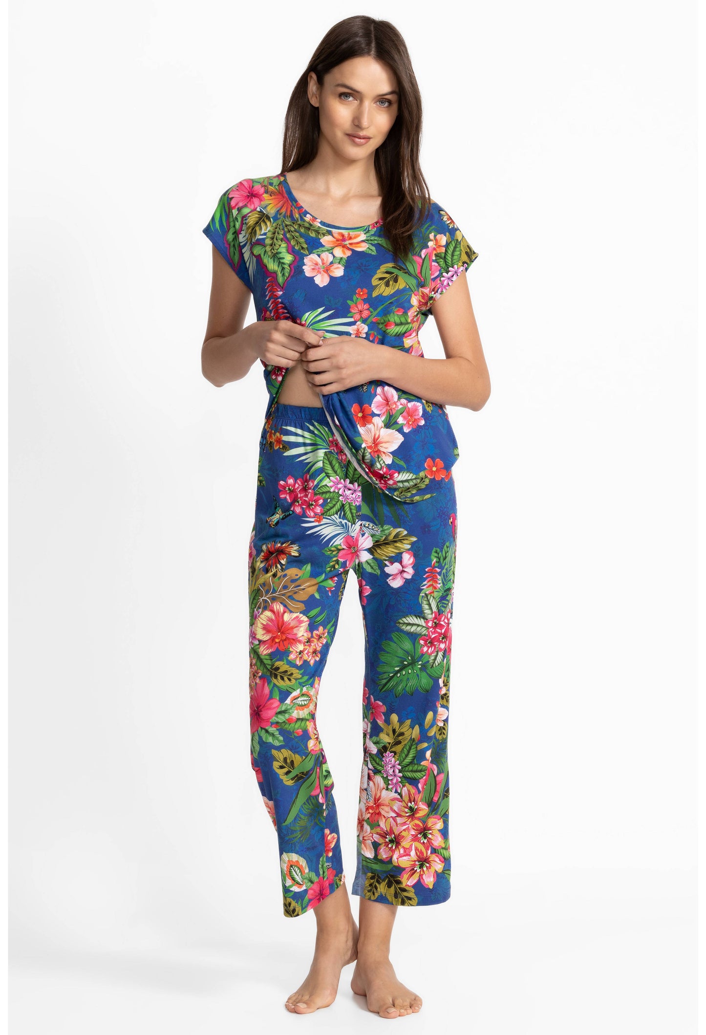 Woman wearing a colorful floral pajama set on a white background