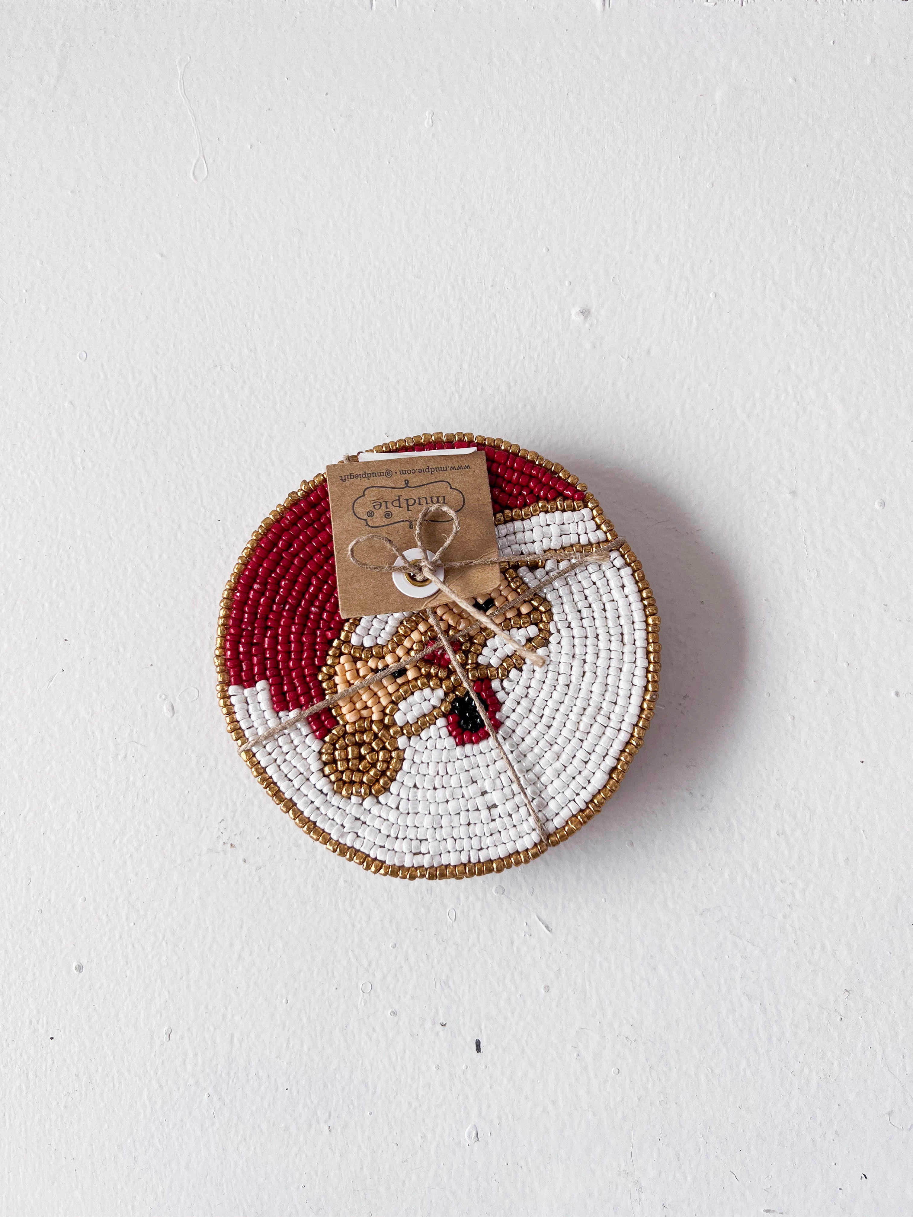 Decorative plate with beaded edge and small figurine on a white background