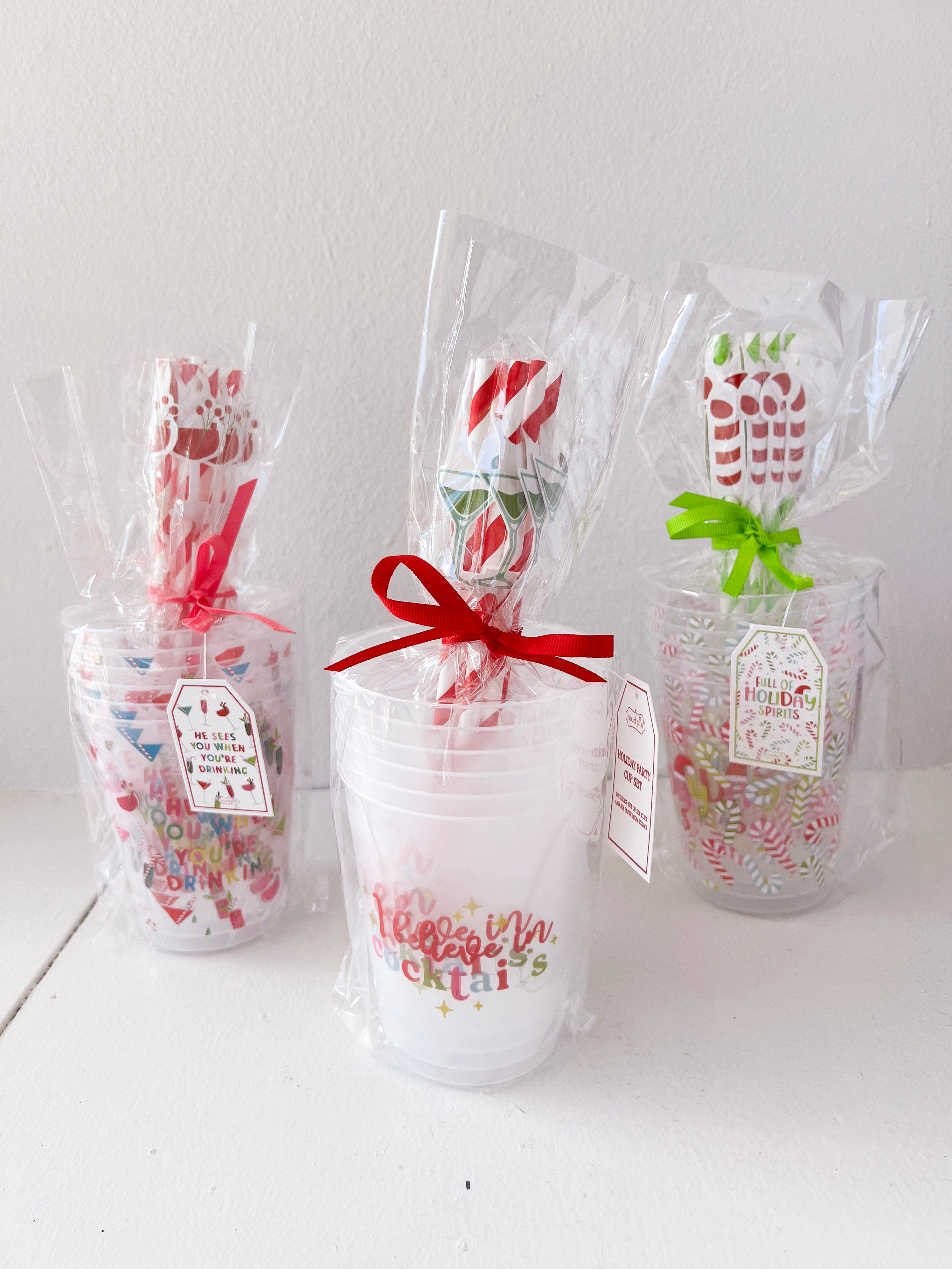 Three clear gift bags with colorful spoons and text on a white surface