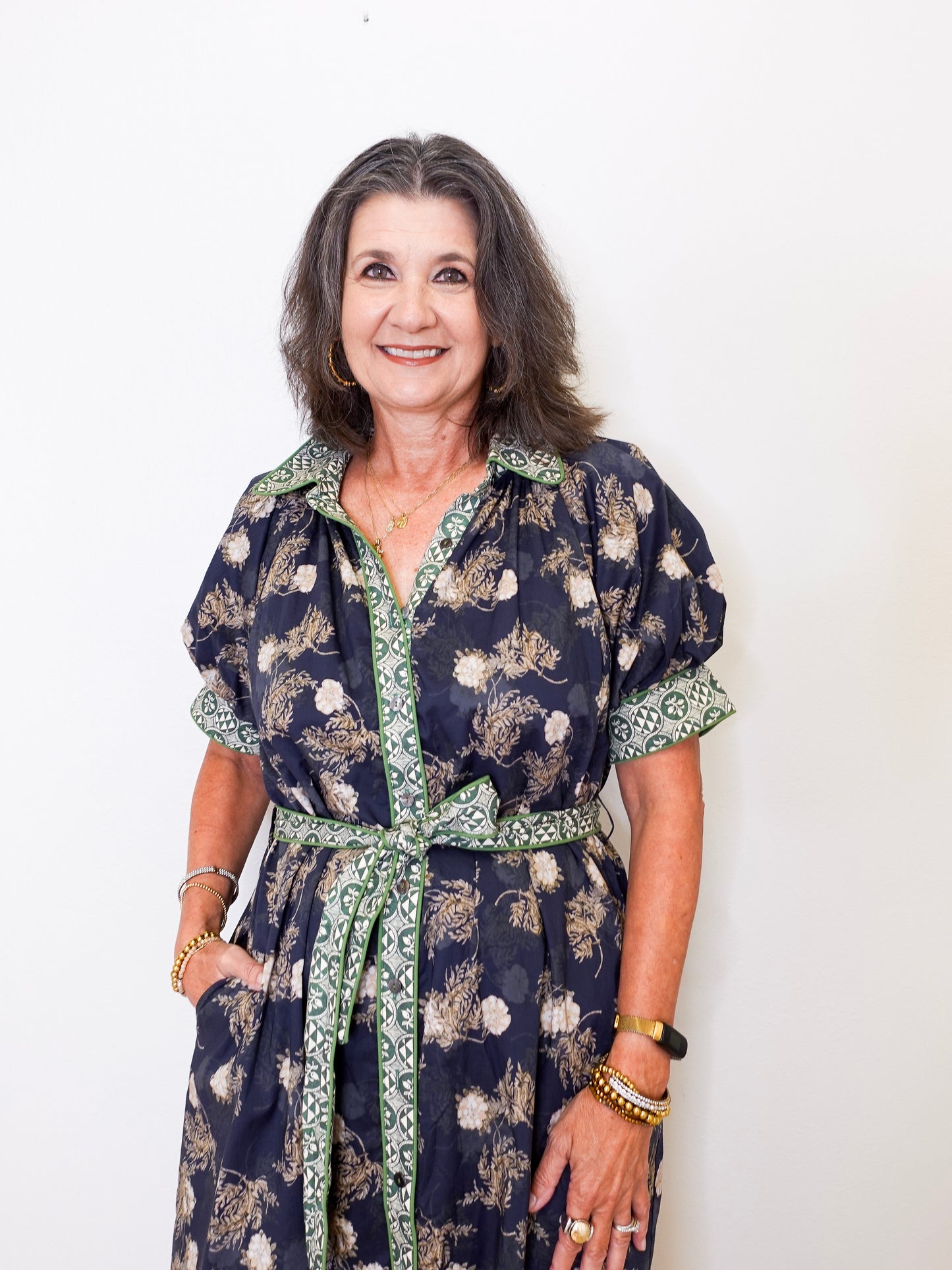 Woman wearing a dark floral dress with a white background