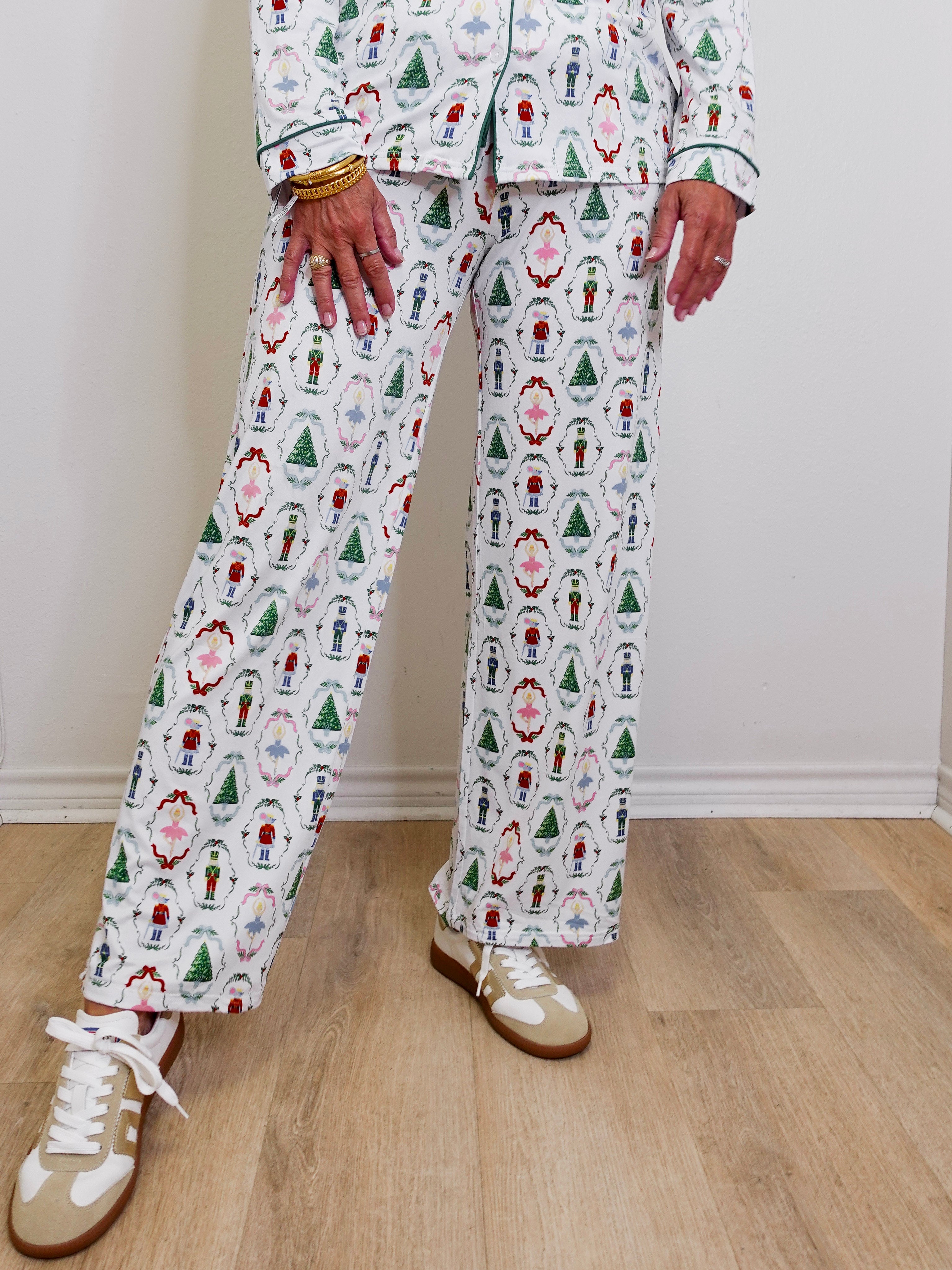 Person wearing a festive pajama set with various patterns on a wooden floor.