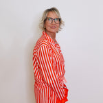 Person wearing a red and white striped outfit against a plain background