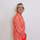 Person wearing a red and white striped outfit against a plain background