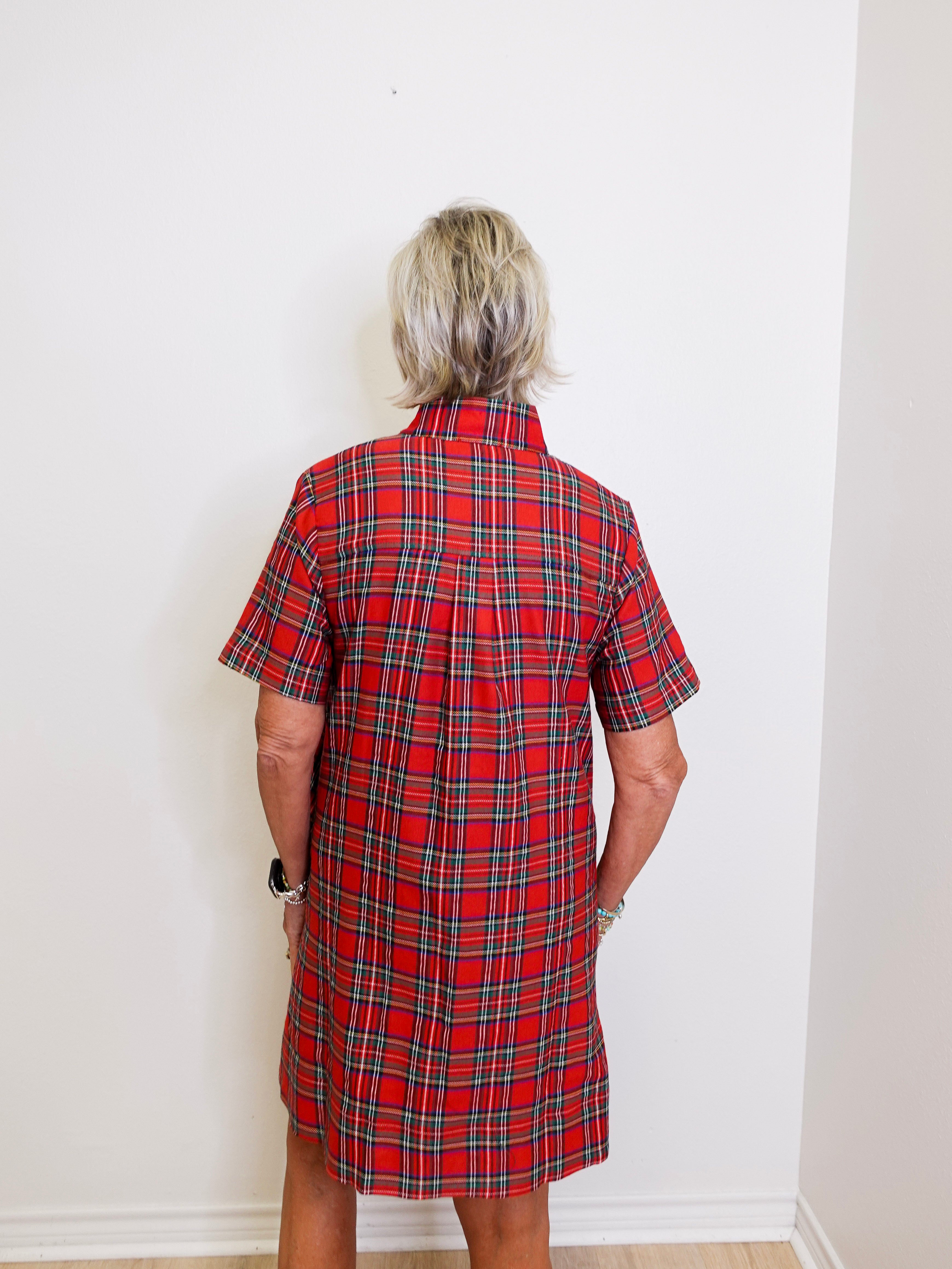 woman wearing a plaid short sleeve dress against a white background