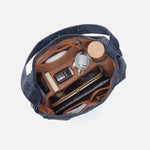 Navy blue bag with brown interior showing various items on a white background