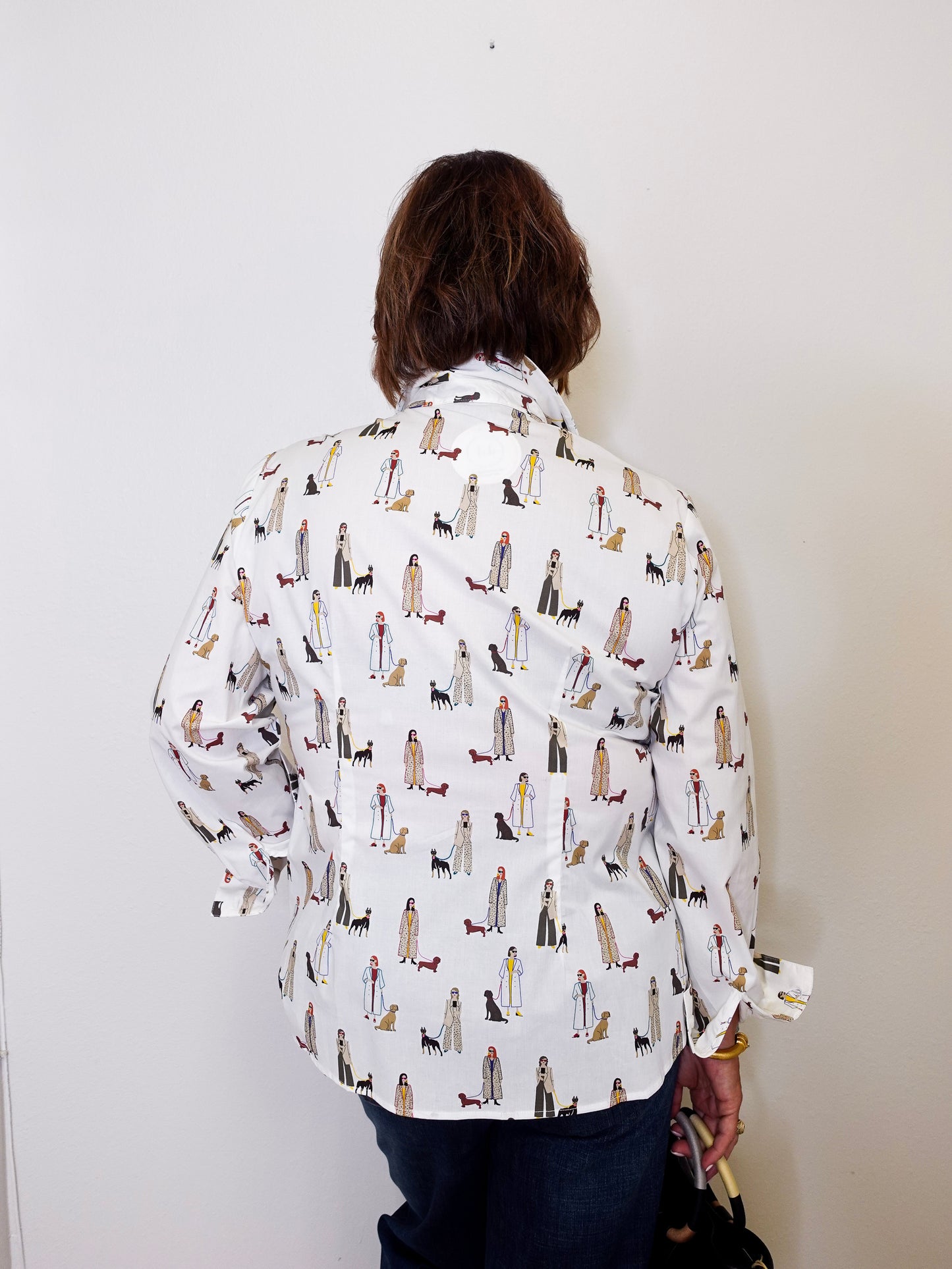 Person wearing a patterned shirt with dogs on a plain background