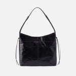 Black leather handbag with a strap on a light gray background