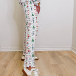 Person wearing a patterned outfit with Christmas-themed design on a wooden floor.