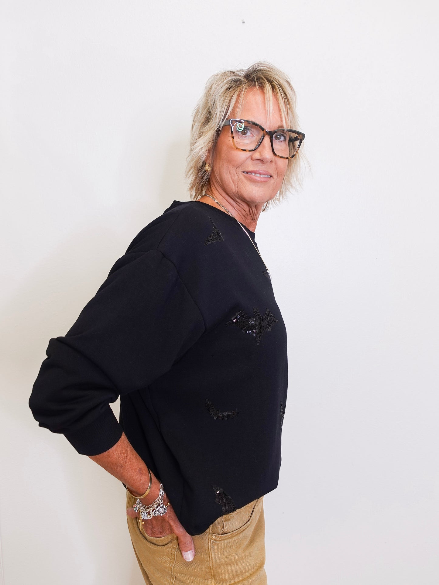 woman wearing a black sweatshirt with black sequins on it