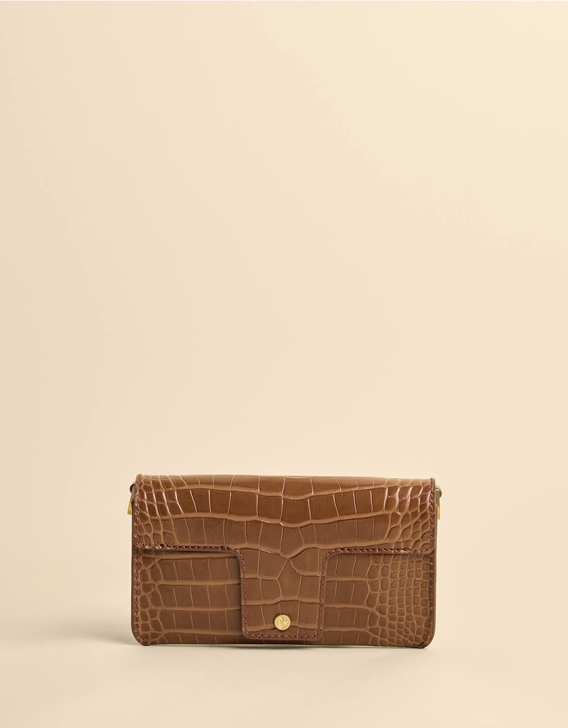 Brown crocodile-patterned wallet on a beige background
