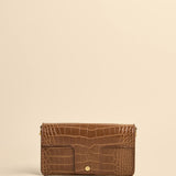 Brown crocodile-patterned wallet on a beige background