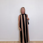 woman wearing a Black and taupe stripe sleeveless maxi dress for special events against a white background.
