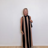 woman wearing a Black and taupe stripe sleeveless maxi dress for special events against a white background.