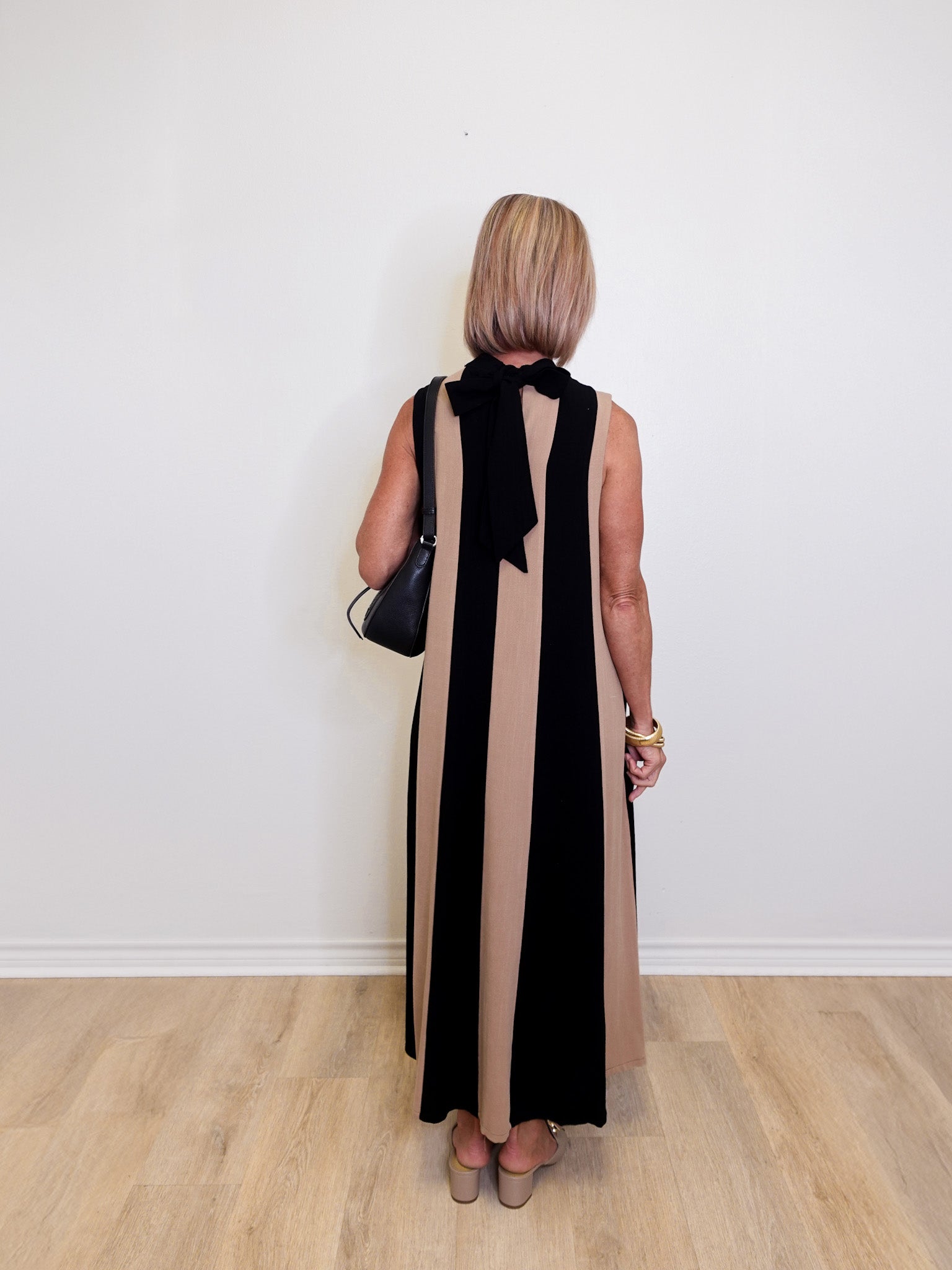 Woman wearing a versatile sleeveless colorblock maxi dress for women against a white background.