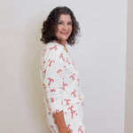 Woman wearing a white floral dress against a plain background