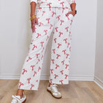 Person wearing a white outfit with red floral patterns on a wooden floor.