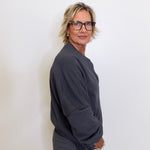 Person wearing a dark gray outfit against a white background