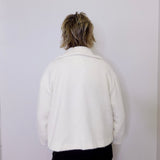 Person wearing a white jacket against a plain background