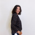 Woman wearing a leopard print jacket against a white background