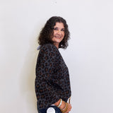 Woman wearing a leopard print jacket against a white background