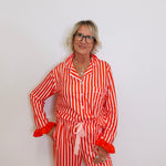 Person wearing a red and white striped pajama set against a plain background