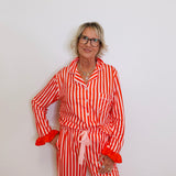 Person wearing a red and white striped pajama set against a plain background