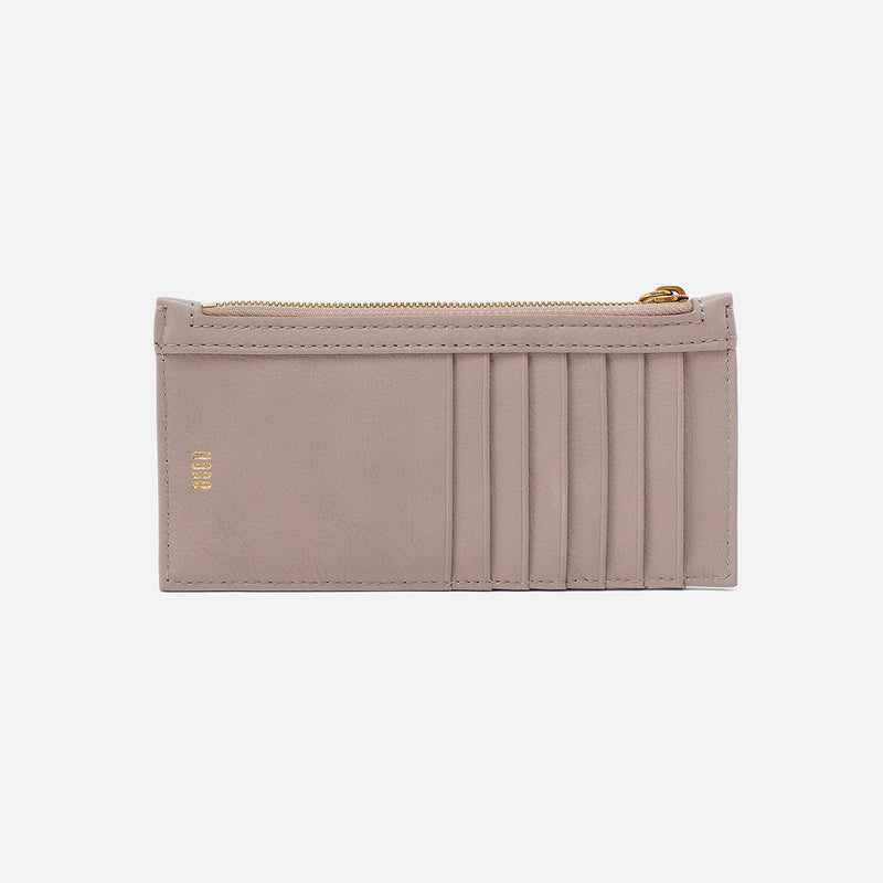 Beige cardholder with gold zipper on a light beige background