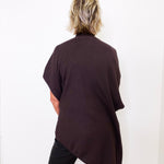 Person wearing a dark brown oversized sweater against a white background