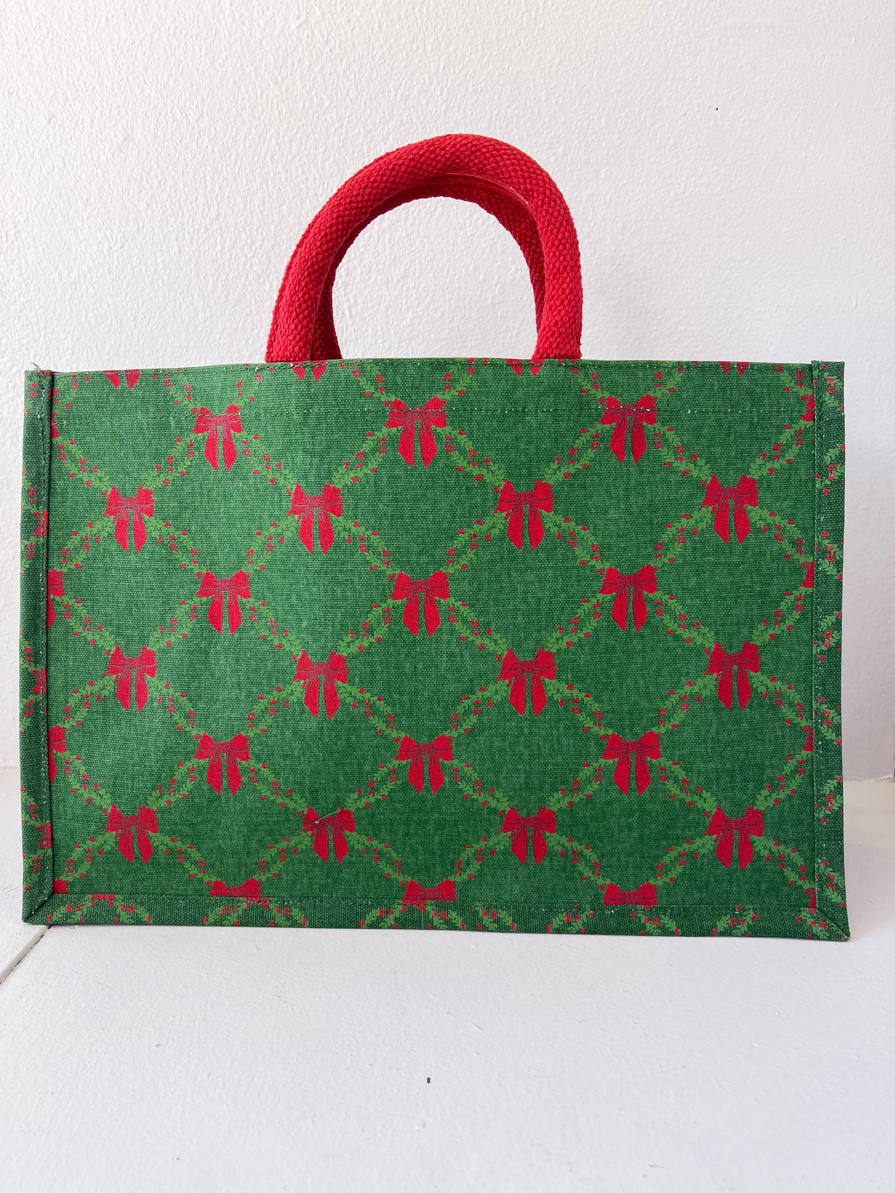 Green bag with red bow pattern and red handle on a white background