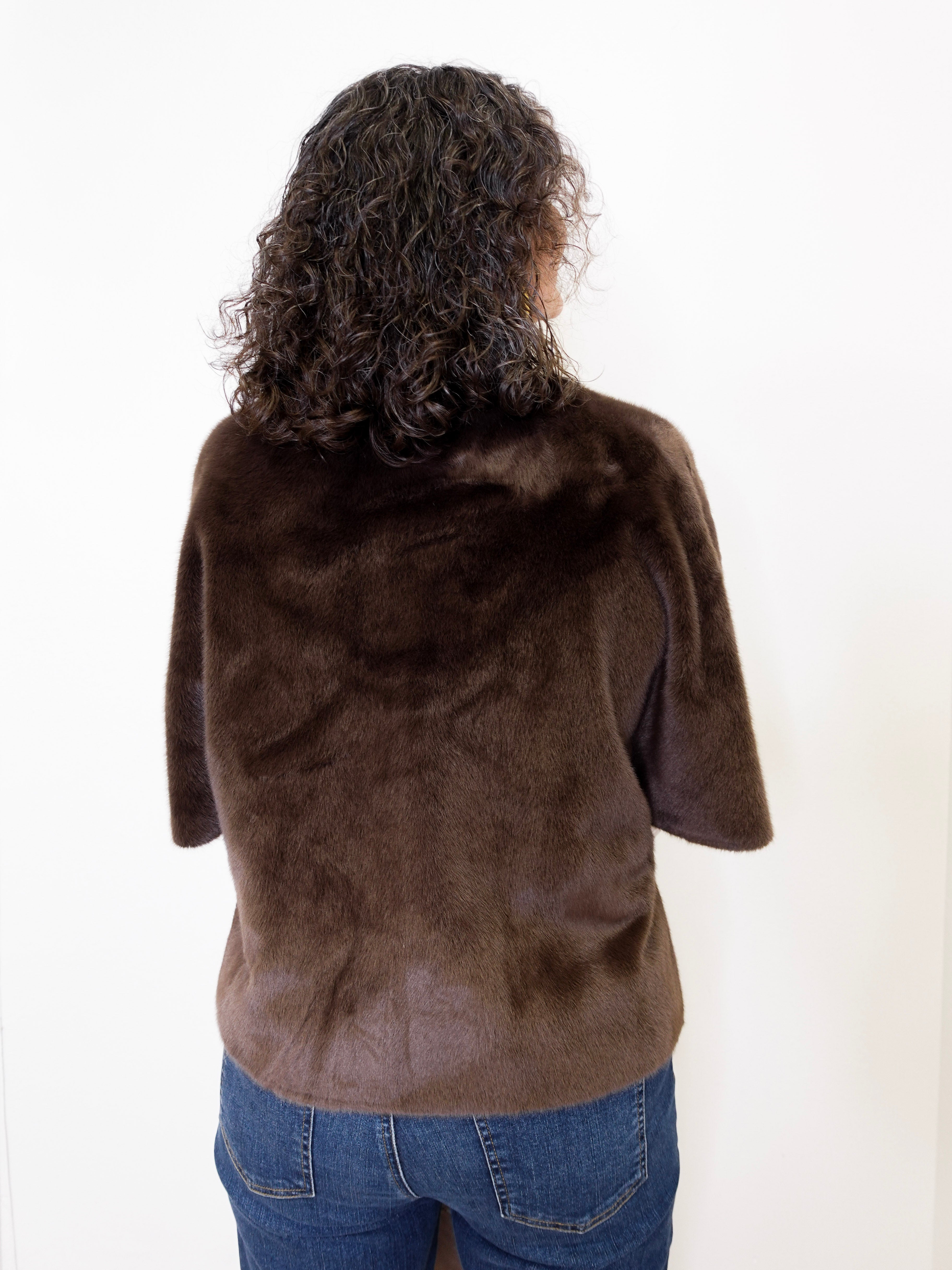 Person wearing a brown fur jacket on a white background