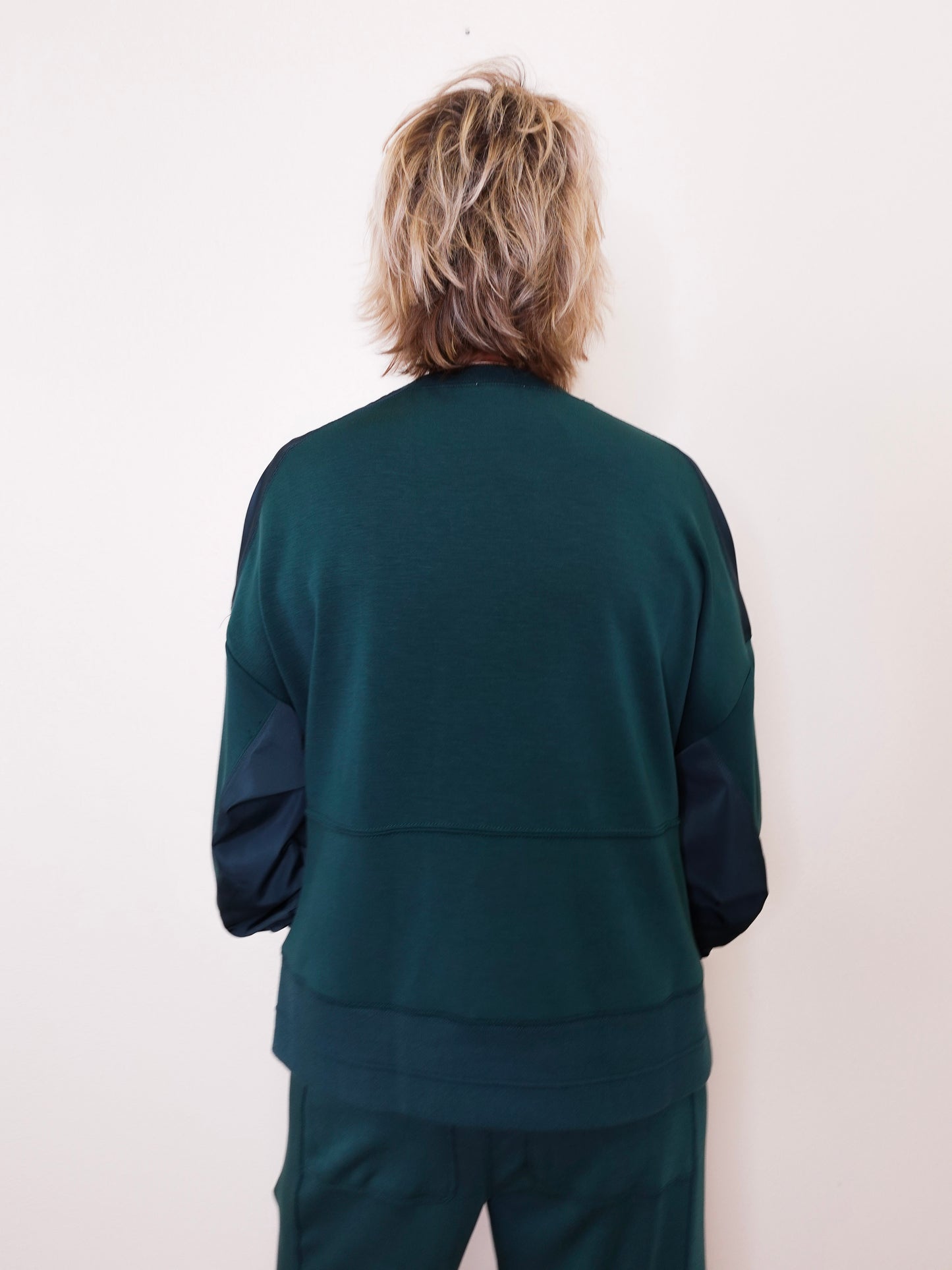 Person wearing a green tracksuit against a white background