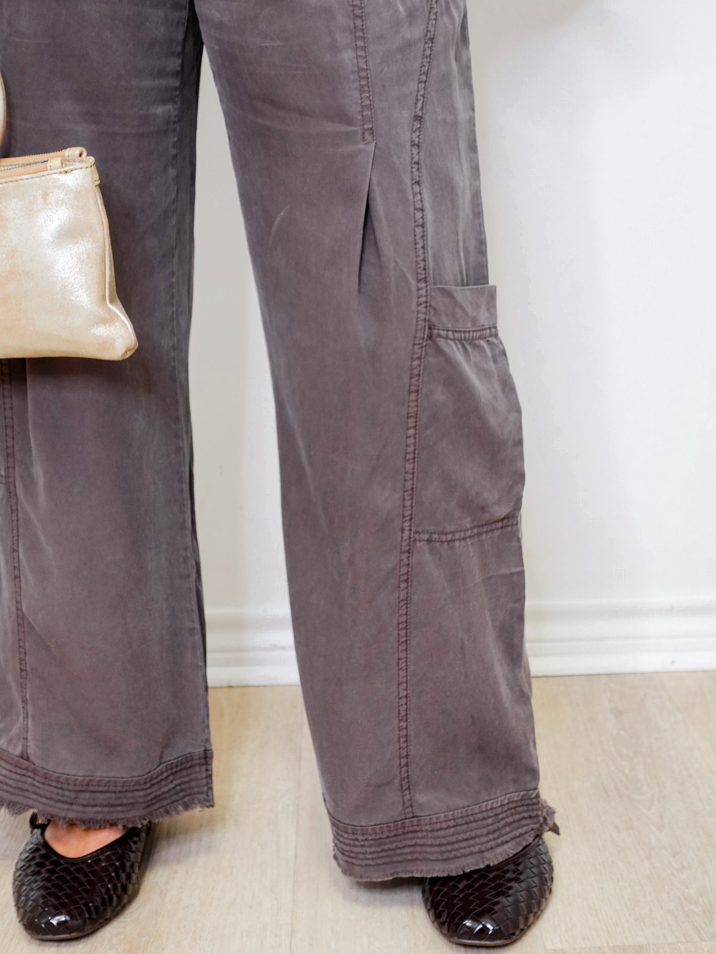 Person wearing gray pants with a white wall background