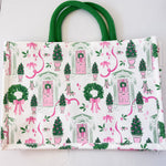 Tote bag with festive design featuring trees, wreaths, and pink ribbons on a white background.