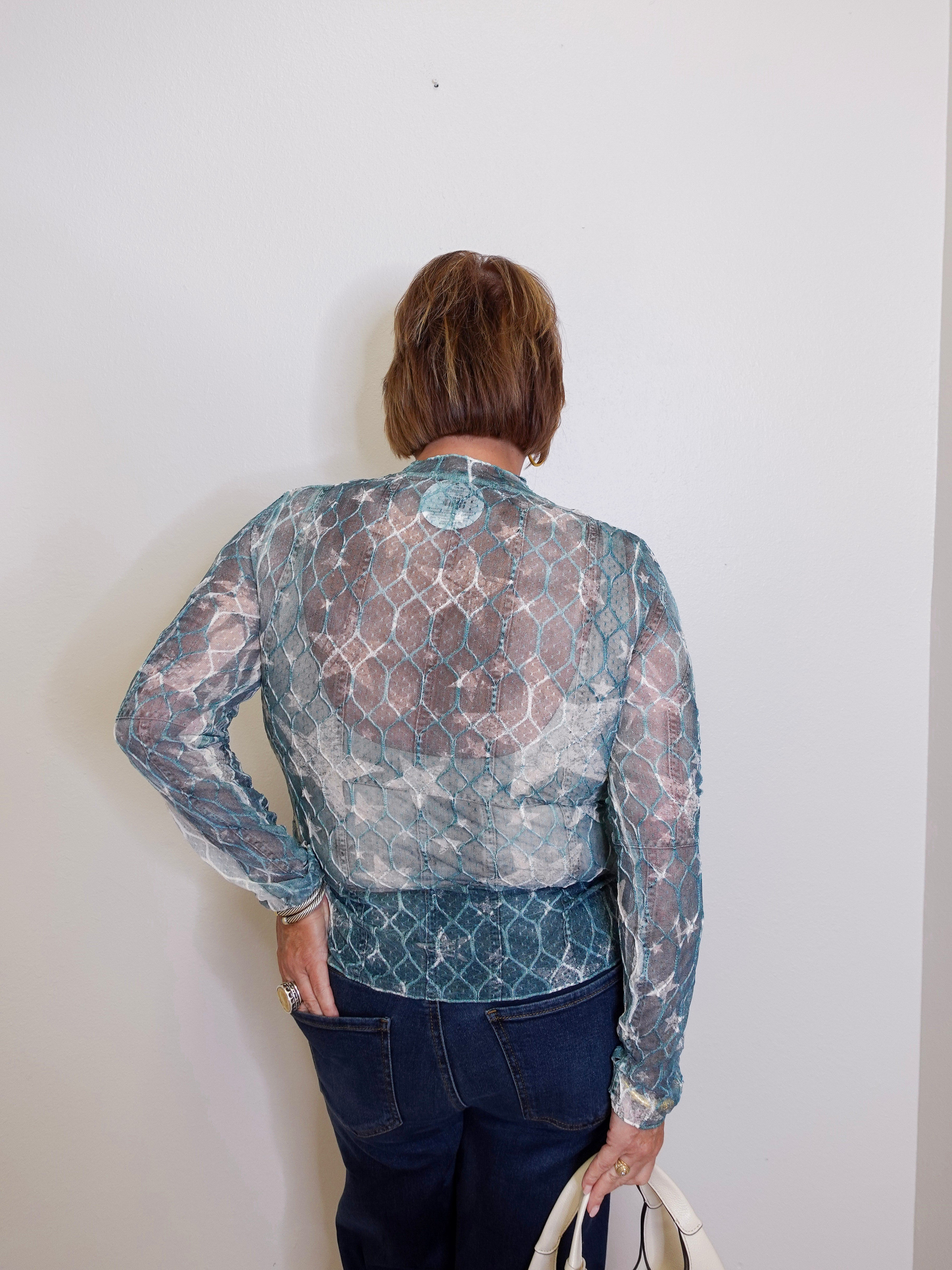 Person wearing a patterned blouse with a plain background