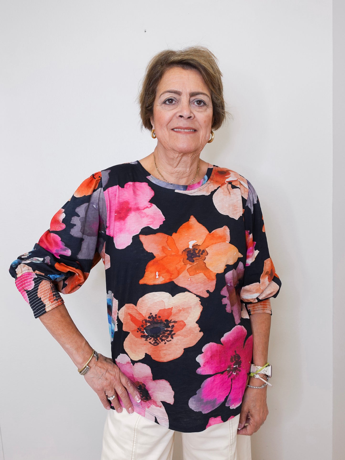 Woman wearing a floral blouse against a plain background