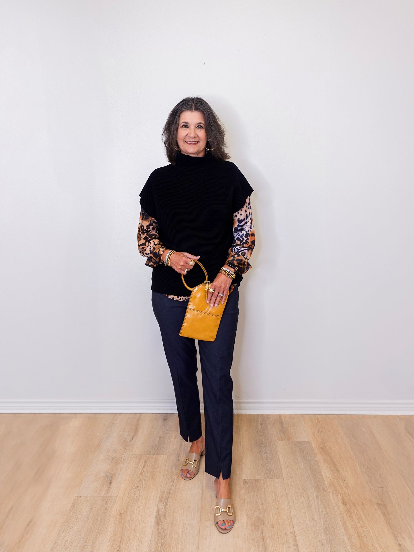 Woman holding a yellow handbag against a white wall