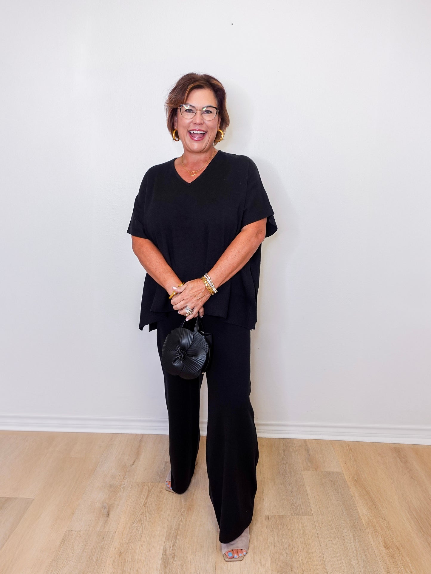 Woman wearing a black outfit against a white wall