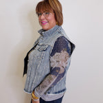 Woman wearing a denim vest over a patterned shirt against a plain background
