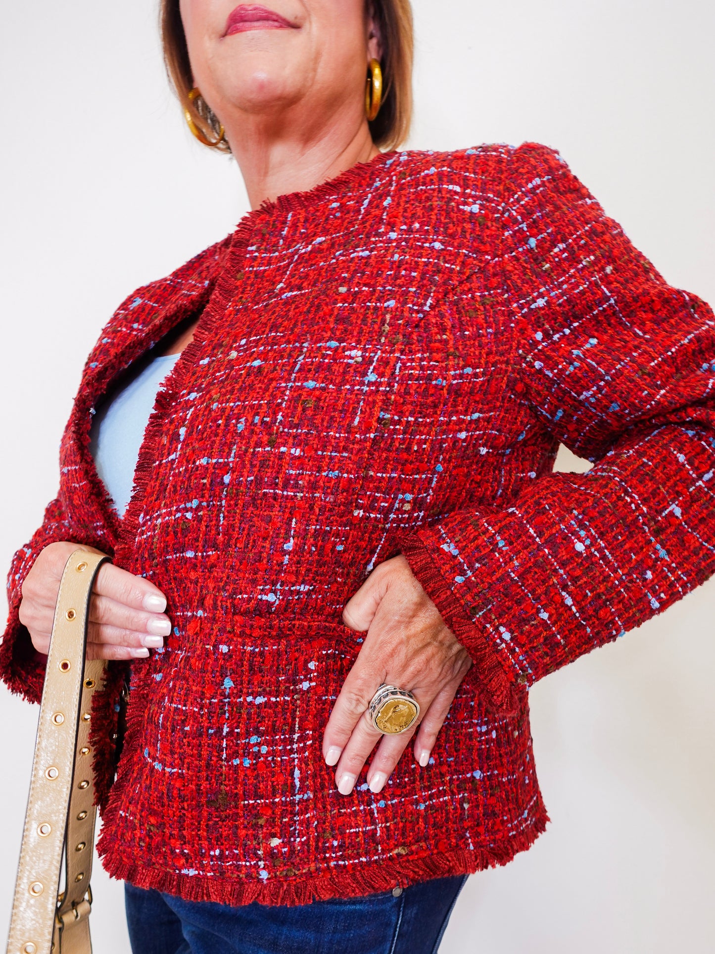 Person wearing a red textured jacket with a plain background
