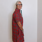 woman wearing a plaid short sleeve dress against a white background