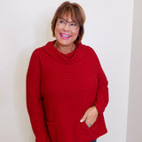 Woman wearing a red sweater against a white background