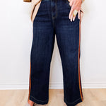 Person wearing dark blue jeans with a white background