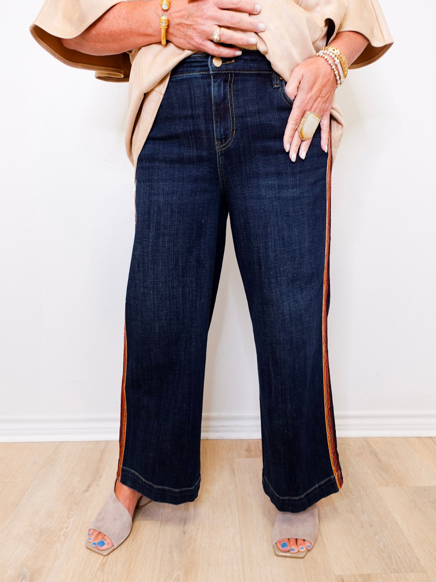 Person wearing dark blue jeans with a white background