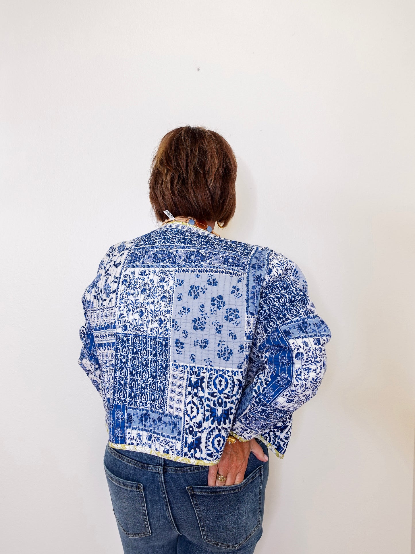 Person wearing a blue and white patterned shirt against a white background