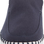 A close-up rear view of a slip-on slipper in dark navy blue suede, featuring a white sole with black contrast stitching around the edge.