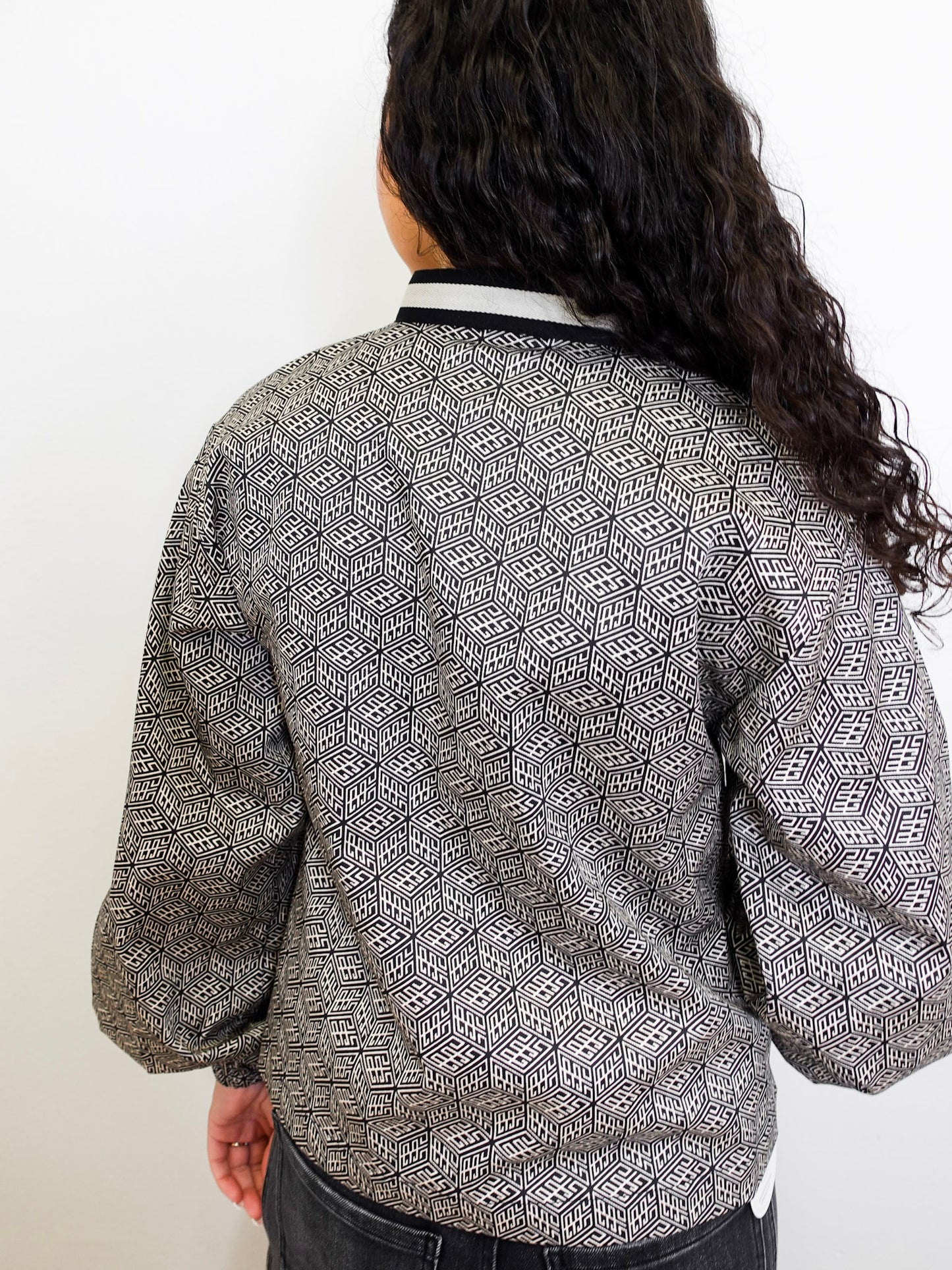 Person wearing a patterned top with a plain background