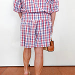 Person wearing a red, white, and blue checkered outfit with shorts and a top.