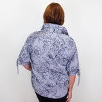 Person wearing a floral-patterned shirt against a white background
