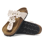 Pair of sandals with white floral decorations on a white background